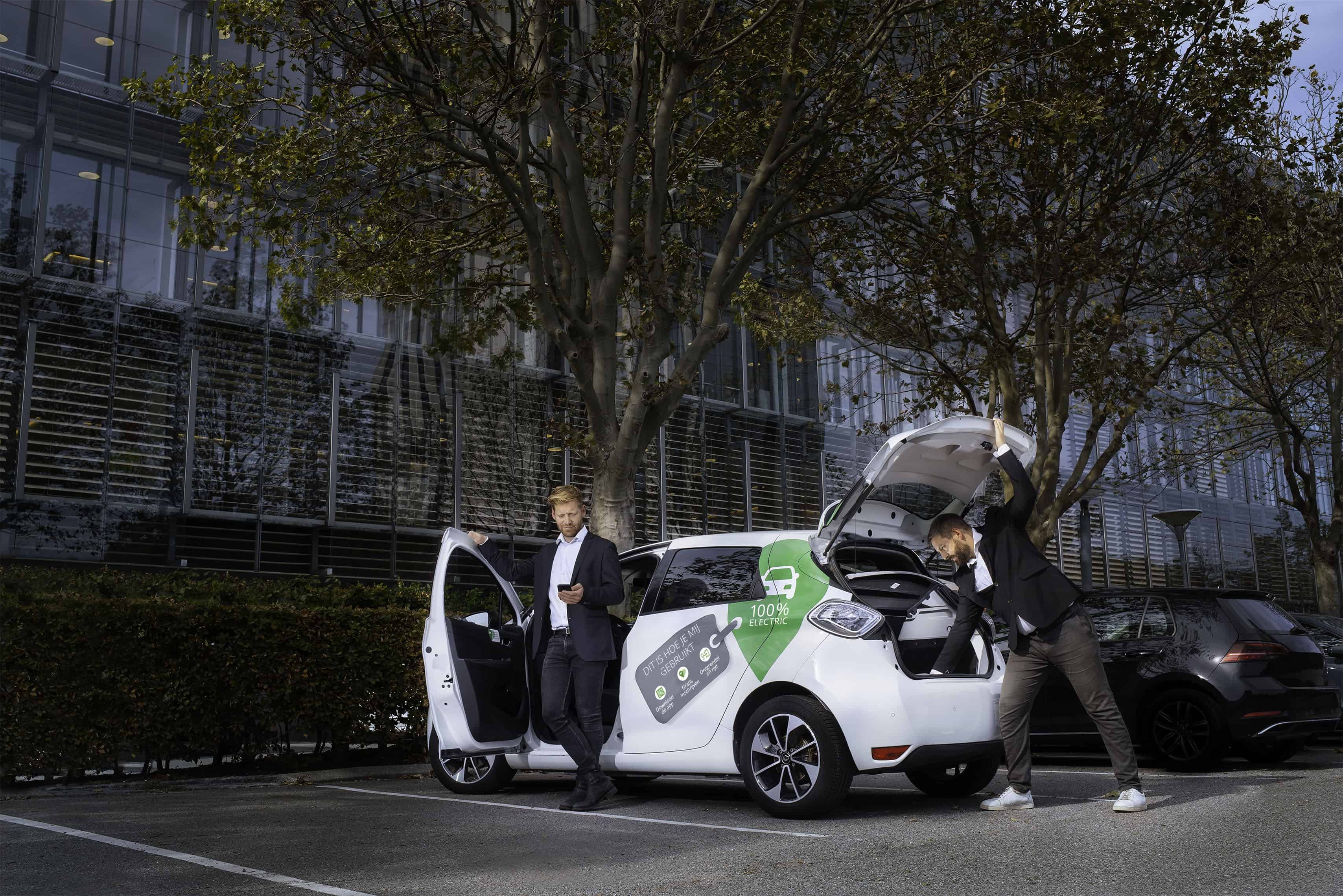 Two business men get our of electric car